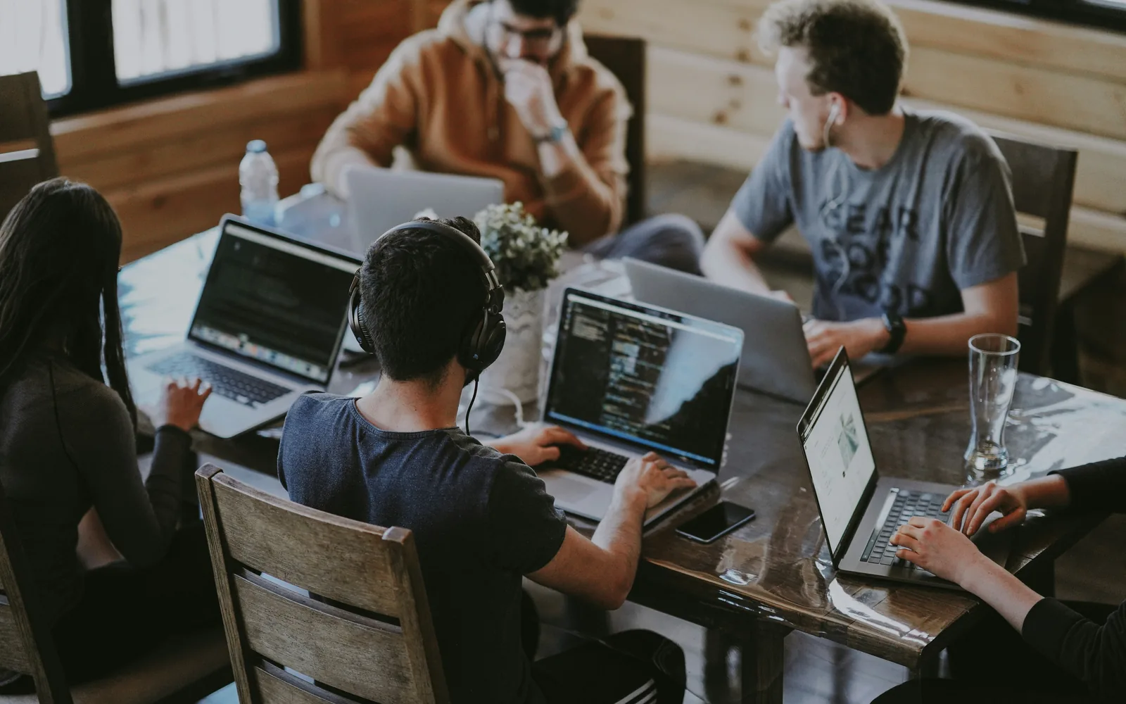 Team collaborating around laptops in a bright workspace